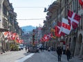 Berne, Switzerland - April 16th 2023: View along the main street decorated with flags in the historic city centre