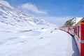 Bernina mountain pass. The famous red train is crossing the white lake. Amazing landscape of the Switzerland land. Famous