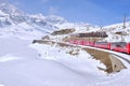 Bernina mountain pass. The famous red train is crossing the white lake. Amazing landscape of the Switzerland land. Famous