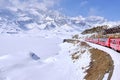 Bernina mountain pass. The famous red train is crossing the white lake. Amazing landscape of the Switzerland land. Famous