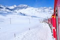 Bernina mountain pass. The famous red train is crossing the white lake. Amazing landscape of the Switzerland land. Famous