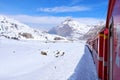 Bernina mountain pass. The famous red train is crossing the white lake. Amazing landscape of the Switzerland land. Famous