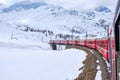 Bernina mountain pass. The famous red train is crossing the white lake. Amazing landscape of the Switzerland land. Famous