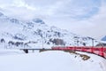 Bernina mountain pass. The famous red train is crossing the white lake. Amazing landscape of the Switzerland land. Famous