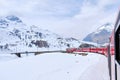Bernina mountain pass. The famous red train is crossing the white lake. Amazing landscape of the Switzerland land. Famous