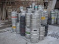 Beroun, Czech Republic, March 23, 2019: close up Pilled empty metal barrels or kegs of czech beer on yard along of brick