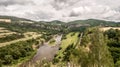 Berounka river with hills, limestone rocks, meadows, fields and railroad track from Tetinska skala in Czech republic