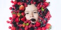 Berrie set. Child face with berry frame, close up. Berries mix blueberry, raspberry, strawberry, blackberry. Assorted Royalty Free Stock Photo