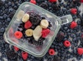 Berries and assorted ingredients in a blender ready to be blended into a smoothie.