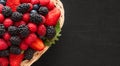 Berries in a basket closeup. Fresh ripe raspberries, blackberries, strawberries and blueberries on black background. Berry mix. Royalty Free Stock Photo