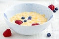 Berries in bowl full of cornflakes and milk for breakfast