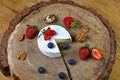 Berries, cheese camembert or brie and ripe strawberry, blueberries and walnuts on a round board. Top view with copy space. set Royalty Free Stock Photo