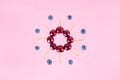 Berries of cherries and blueberries arranged in a circle. Pink background. Concept of berries season and proper nutrition