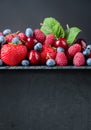 Berries closeup colorful assorted mix on a dark stone background Royalty Free Stock Photo