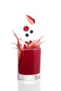 Berries falling into glass with red fruit juice