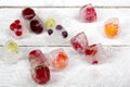 Berries frozen in ice cubes with mint on wooden table background. Royalty Free Stock Photo