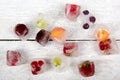 Berries frozen in ice cubes on wooden table background. Royalty Free Stock Photo