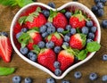 Berries in heart shaped bowl. Healthy eating concept. Royalty Free Stock Photo