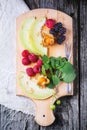 Berries, mint and melon on wooden cutting board Royalty Free Stock Photo