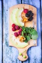 Berries, mint and melon on wooden cutting board Royalty Free Stock Photo