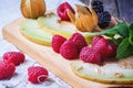 Berries, mint and melon on wooden cutting board Royalty Free Stock Photo