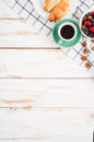 Berries, nuts, croissans and cup of coffee on wooden background