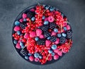 Berries on a plate, a mix of colored berries, blueberries, raspberries,blackberries, red currants, diet, vitamins, on a gray Royalty Free Stock Photo