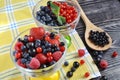 Berries are red and blue in a glass bowl on a black wooden background Royalty Free Stock Photo