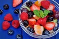 Berries salad in a transparent bowl on wooden table Royalty Free Stock Photo