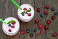 Berries smoothies in two glasses with straws on wooden table Royalty Free Stock Photo