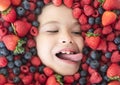 Berry banner. Berries child face close up. Top view photo of child face with berri. Berry set near kids face. Cute Royalty Free Stock Photo