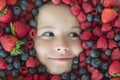 Berry banner. Kids face with close-up berry. Berries mix of strawberry, blueberry, raspberry, blackberry. Assorted mix Royalty Free Stock Photo