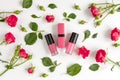 Berry color decorative cosmetics with roses white background top view