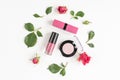 Berry color decorative cosmetics with roses white background top view