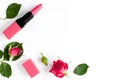 Berry color decorative cosmetics with roses white background top view