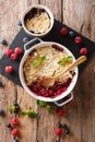 Berry crumble with currants, raspberries and blueberries decorated with mint close up. Vertical top view Royalty Free Stock Photo