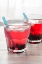 Berry drink of red color with currant and ice in a glass. The sweaters are saved with a cocktail. Royalty Free Stock Photo