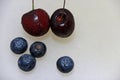 Berry fruit and cherry on the white floor. Berry is a small roundish juicy fruit.