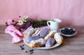 Berry glazed eclairs with blueberries on a wooden background with a decor consisting of a vase with wildflowers and a Royalty Free Stock Photo