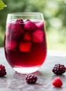 Berry hibiscus iced tea in a glass with a background of fresh mixed berries and hibiscus flowers. AI generated. Royalty Free Stock Photo
