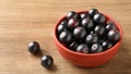 Berry Jaboticaba in bowl on wooden table. Generative AI Royalty Free Stock Photo
