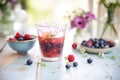 berry juice in clear cup, dewy berries scattered nearby