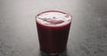 berry juice in a thin wall glass on concrete countertop with copy space