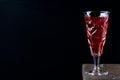 Berry liquor in crystal vintage shot glass on black