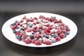 A Berry mix in sugar from frozen raspberries and blueberries on the white plate. A Frozen Berries with Sugar.  A sweet background Royalty Free Stock Photo