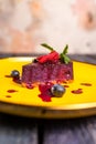 berry mousse with strawberries on a yellow plate