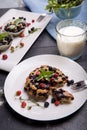 Berry muffin with blueberries and strawberries on a white plate and a wooden table served with milk and and fresh Royalty Free Stock Photo