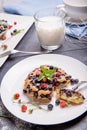 Berry muffin with blueberries and strawberries on a white plate and a wooden table served with milk and and fresh Royalty Free Stock Photo