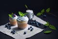 berry muffins with cream on a dark background. Royalty Free Stock Photo