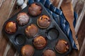 Berry muffins topped with powdered sugar on a wooden